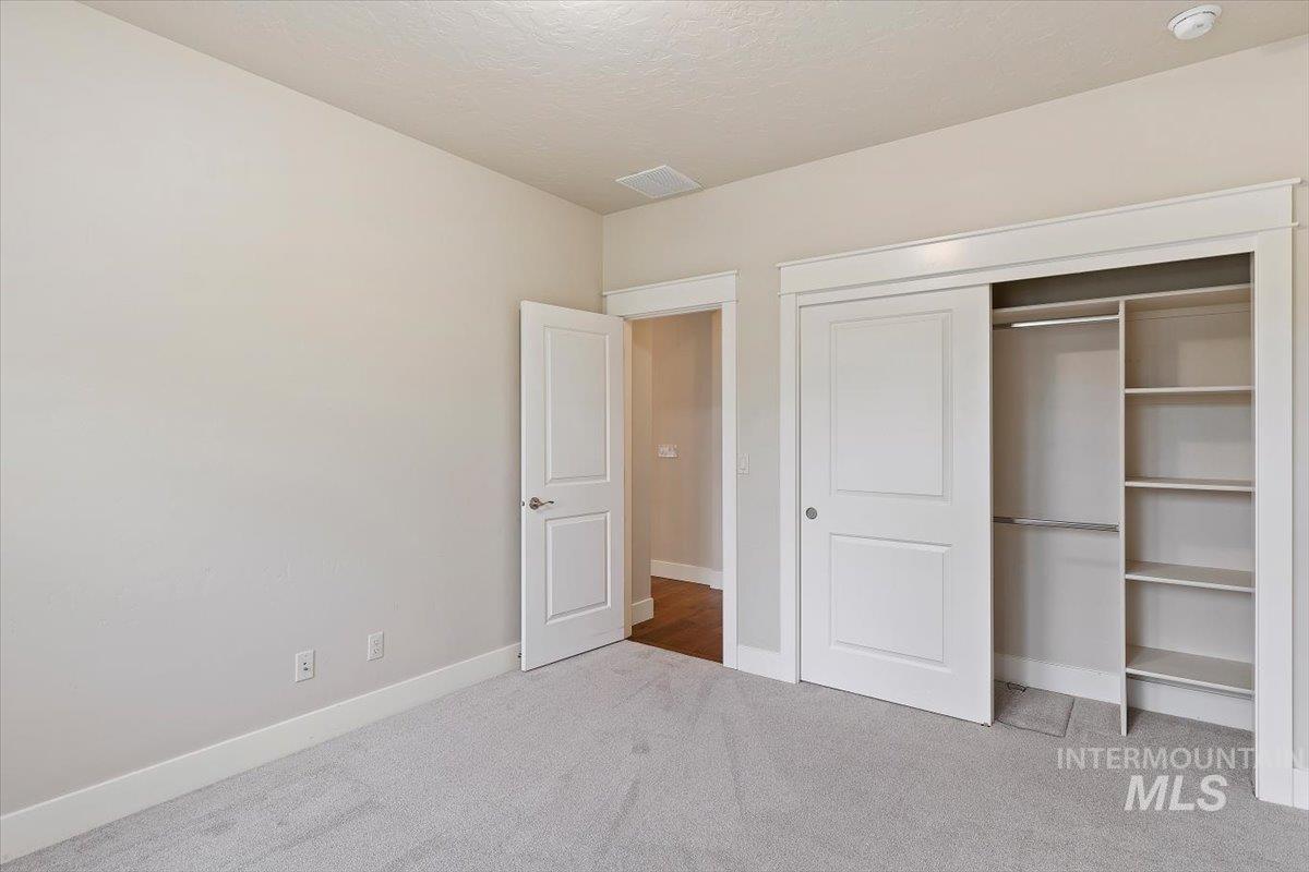 1366 North Waterbrook Way Star, ID 83669 - Photo 20 of 30 Unfurnished bedroom with light carpet, a closet, and a textured ceiling