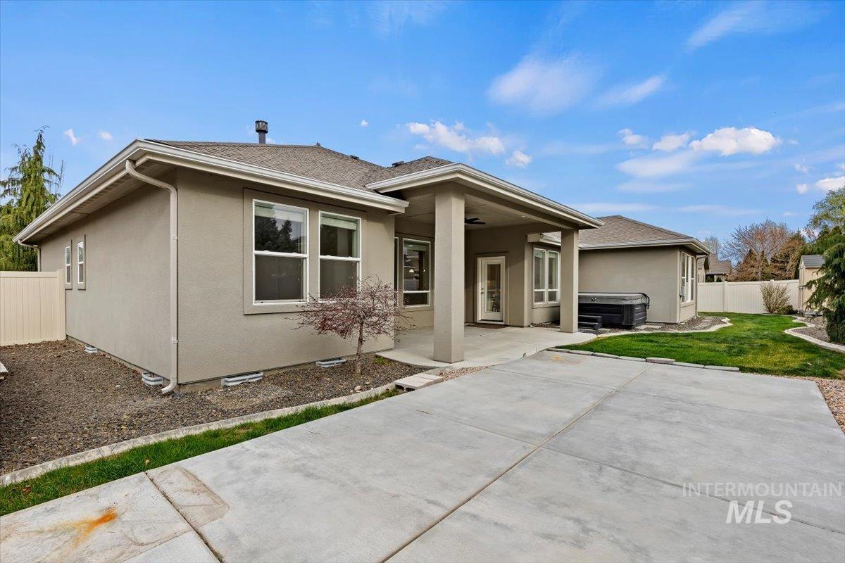 1366 North Waterbrook Way Star, ID 83669 - Photo 28 of 30 View of front facade featuring stucco siding, a patio area, a hot tub, and a shingled roof