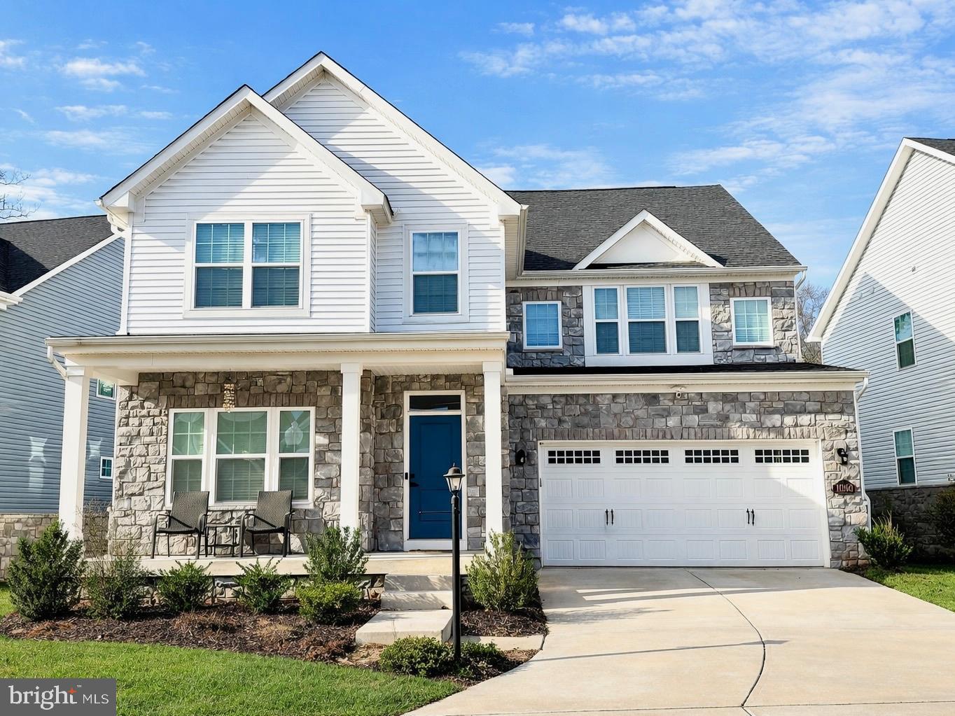 Charming home with stone accents and greenery.