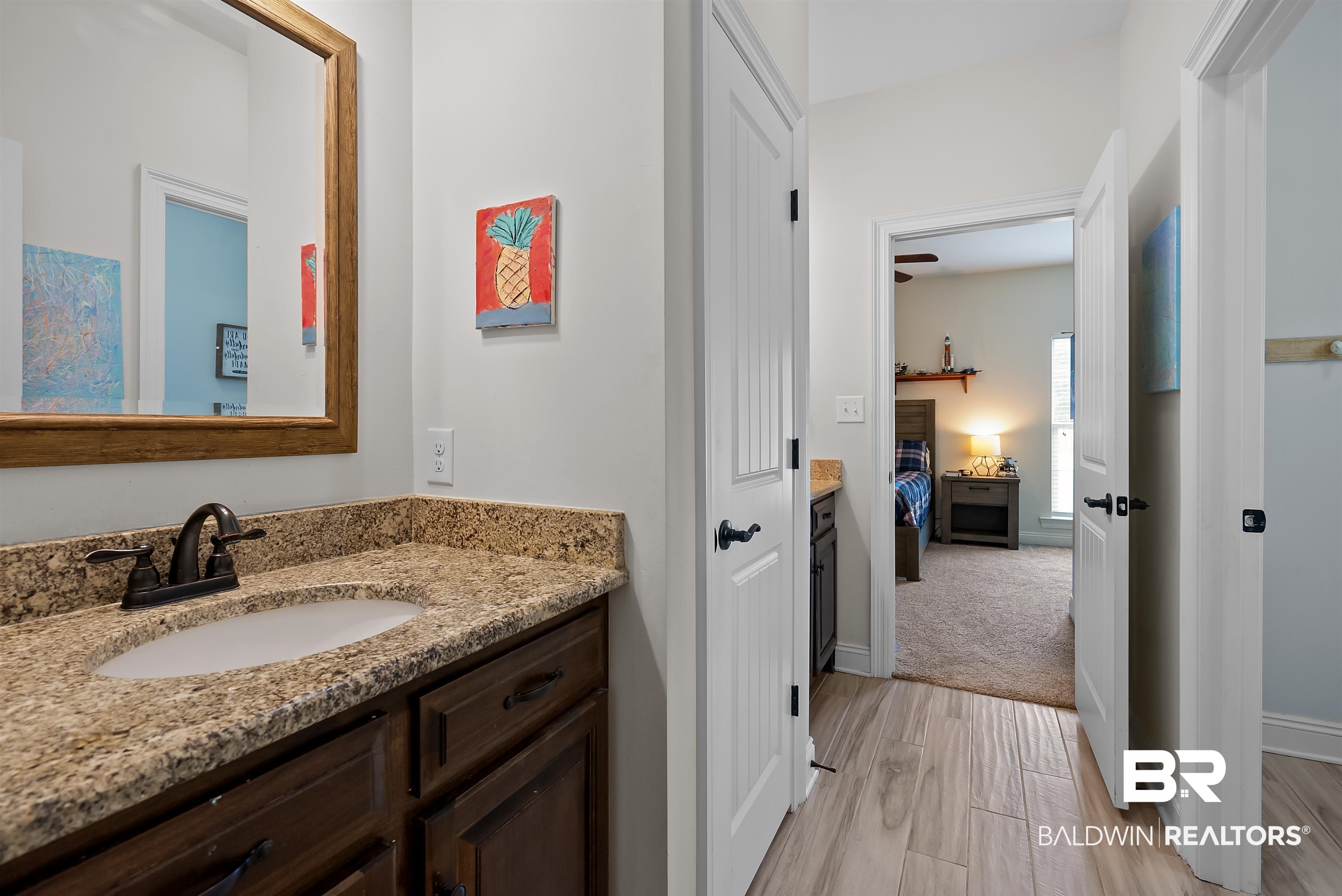 12070 Comalander Road Fairhope, AL 36532 - Photo 32 of 50 Vanity with a granite countertop and an undermount sink, accented by a bronze-finish faucet