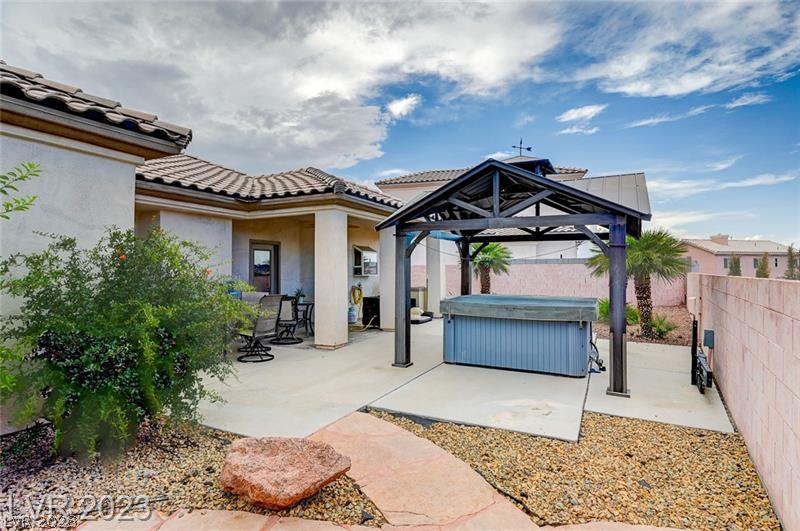987 Cutter Street Henderson, NV 89011 - Photo 2 of 17 A spacious backyard features a covered patio, a relaxing spa, and mature landscaping for private outdoor enjoyment.