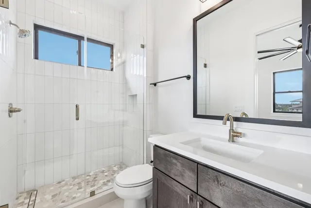 a bathroom with a sink a toilet and shower