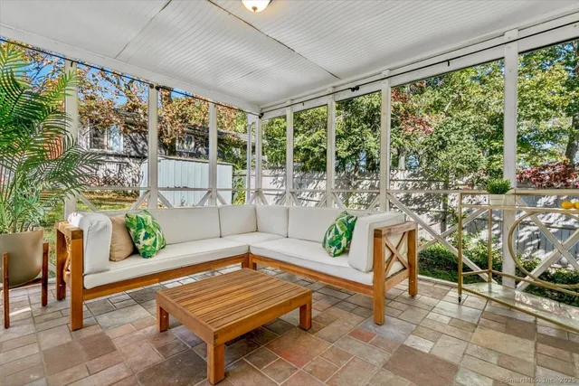 a living room with patio furniture and a potted plant