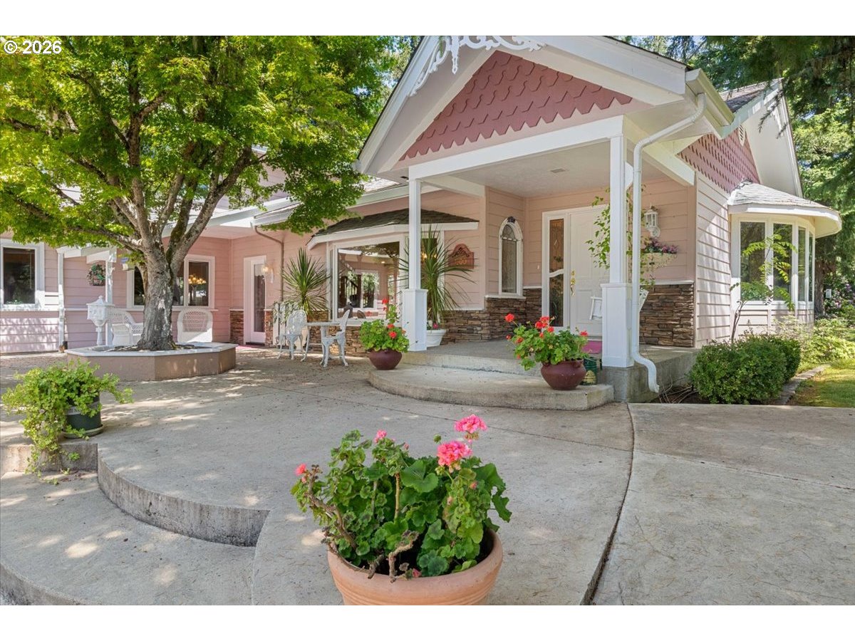 1300 Fair Oaks Road Oakland, OR 97462 - Photo 4 of 48 a view of a white house with potted plants and a large tree