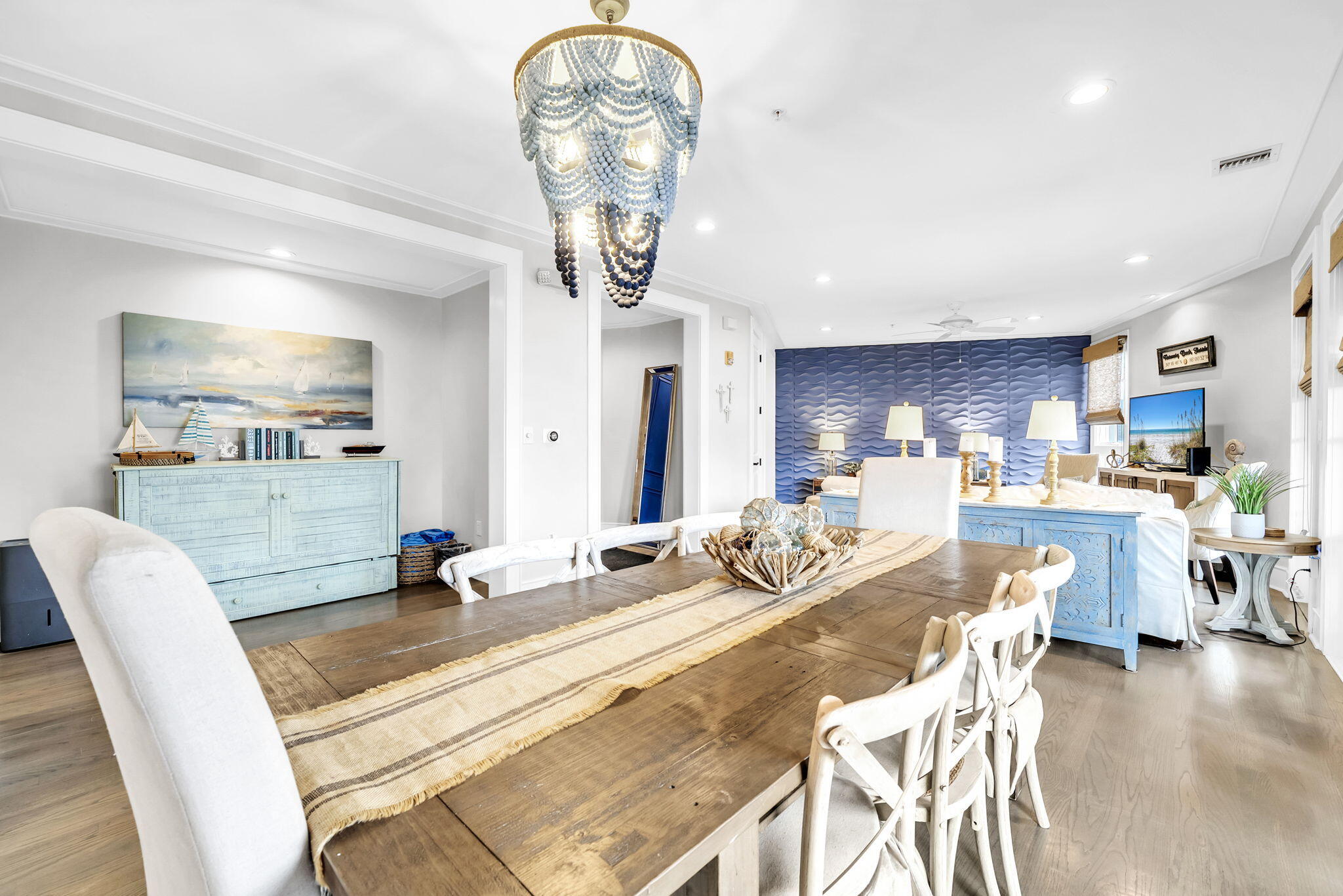 82 South Barrett Square, Unit 3E Inlet Beach, FL 32461 - Photo 16 of 56 a view of a dining room and livingroom with furniture wooden floor a rug a painting and a chandelier