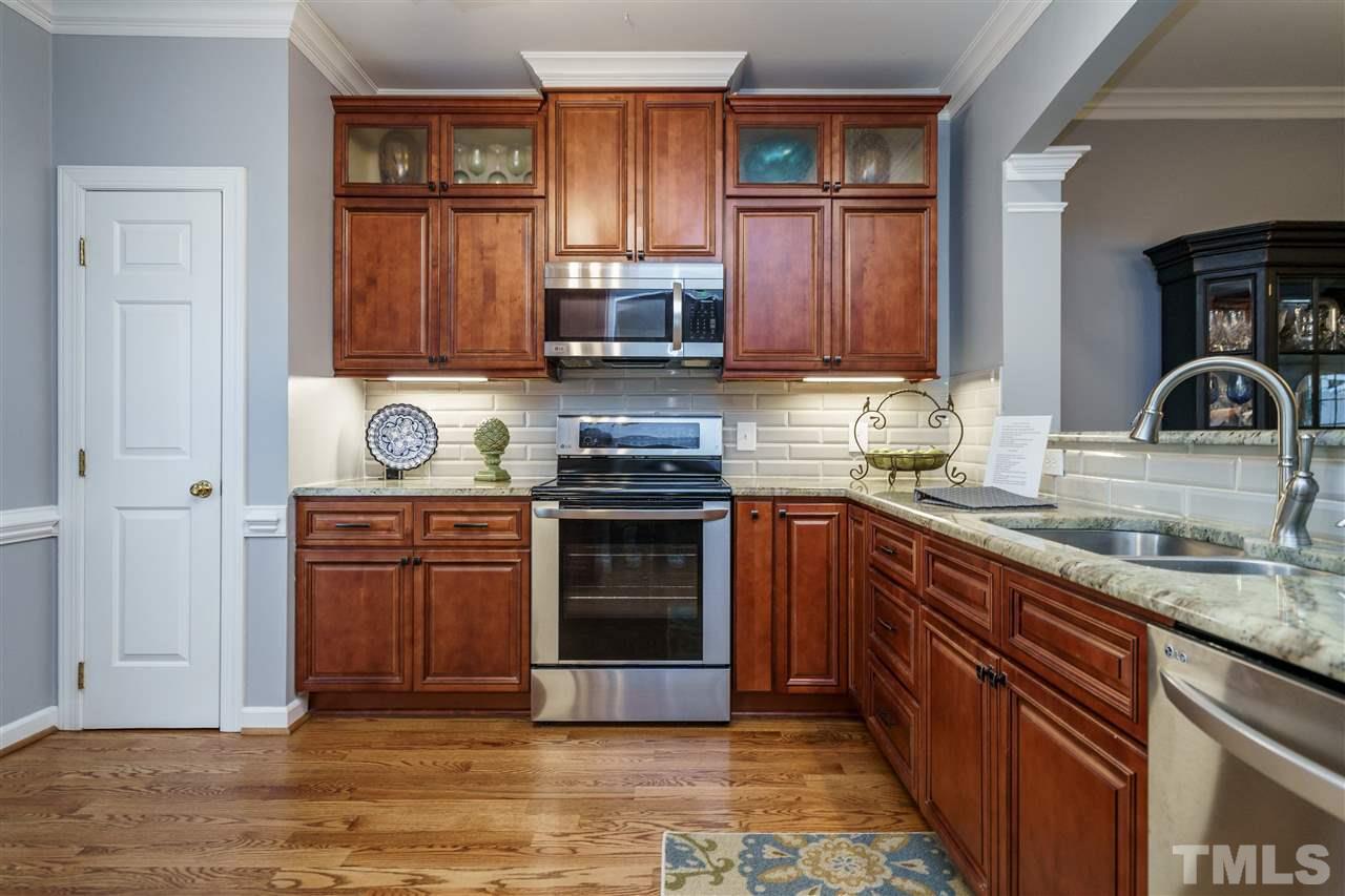 772 Weathergreen Drive Raleigh, NC 27615 - Photo 5 of 26 Upgraded granite and cabinets with under cabinet lighting and some glass fronts. Separate pantry.