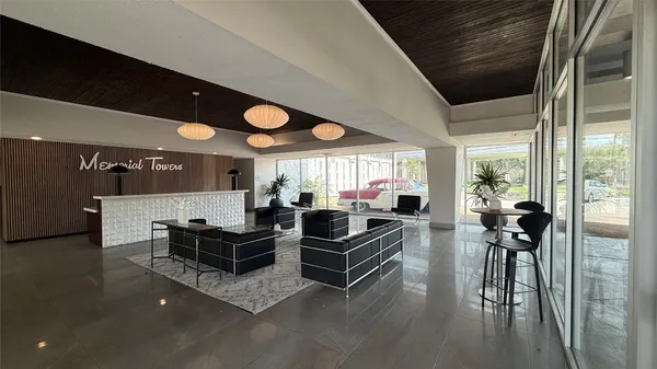 a living room with furniture a large window and a chandelier