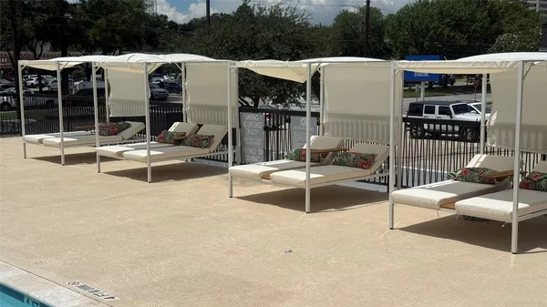 a view of a patio with couches chairs and floor to ceiling window