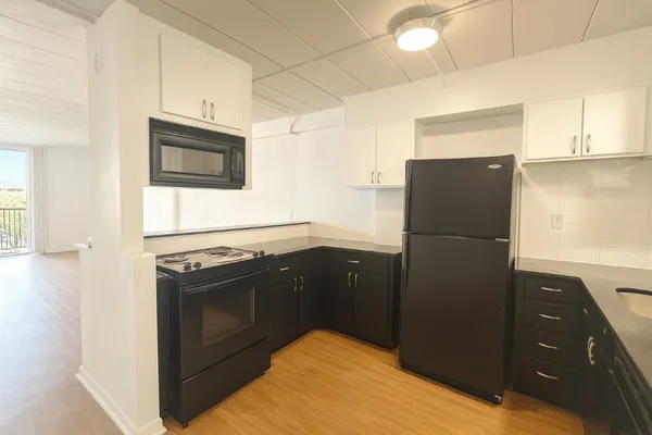 a kitchen with stainless steel appliances granite countertop a refrigerator and a stove top oven