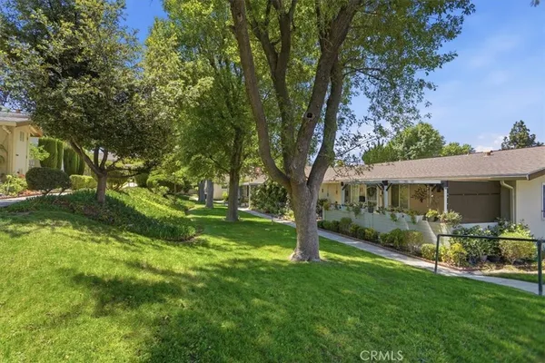 a view of backyard of house with green space