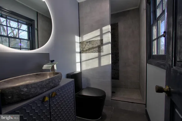 a bathroom with a granite countertop sink a toilet and a mirror