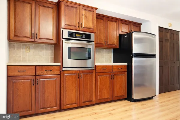 a kitchen with stainless steel appliances granite countertop a refrigerator a microwave and cabinets