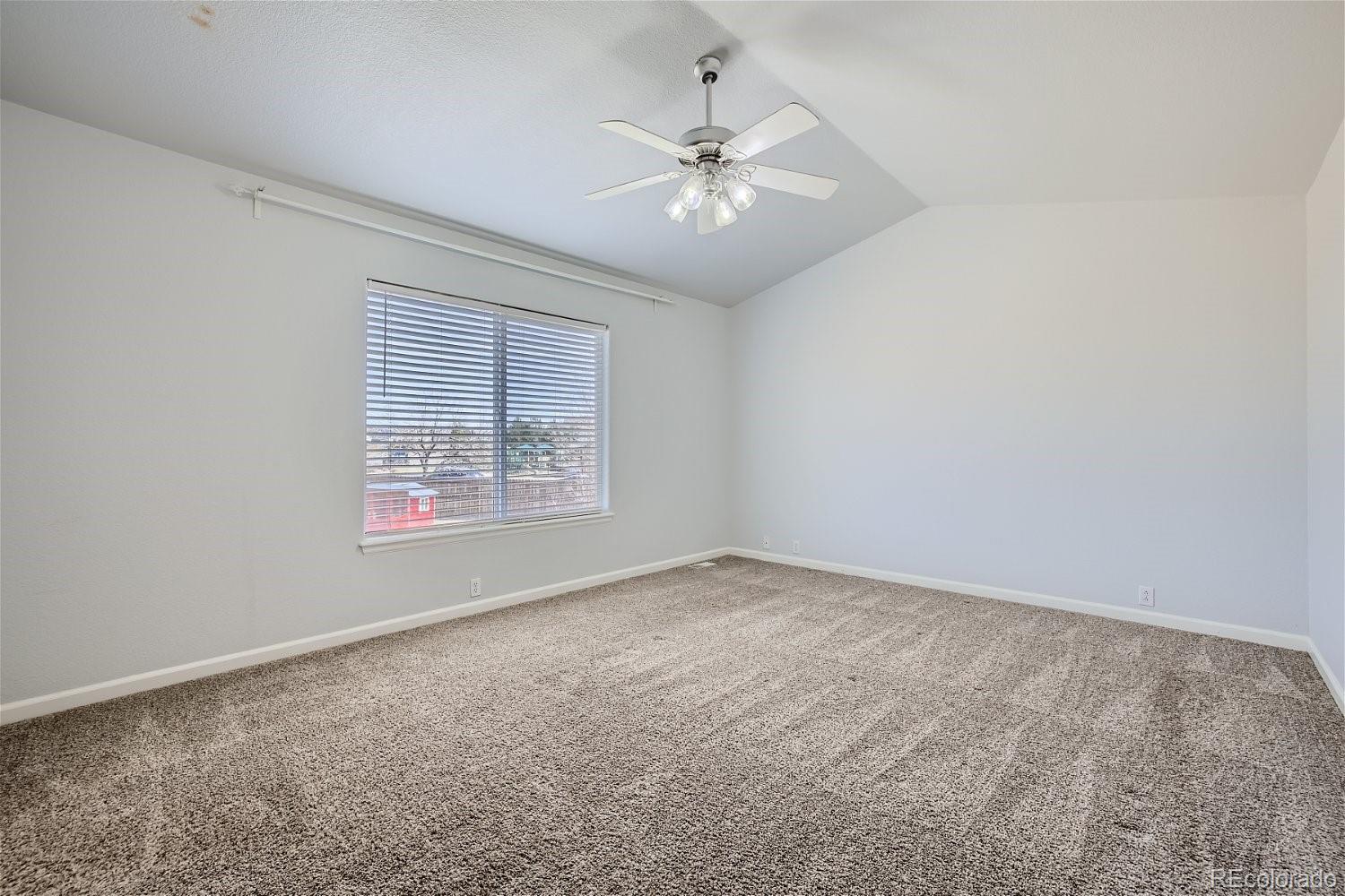6632 Balance Circle Colorado Springs, CO 80923 - Photo 13 of 28 an empty room with windows and chandelier fan