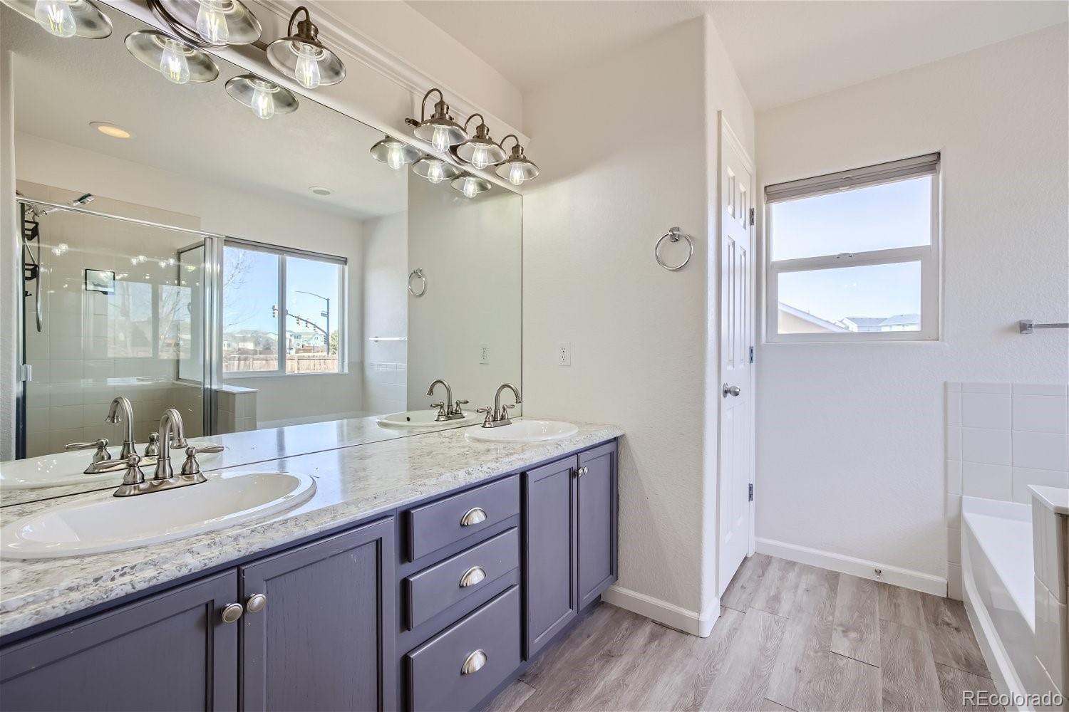 6632 Balance Circle Colorado Springs, CO 80923 - Photo 15 of 28 a bathroom with a granite countertop sink a mirror and a shower