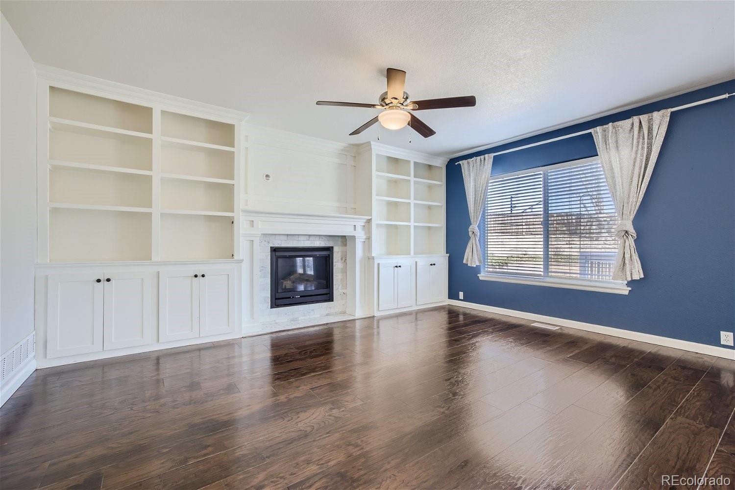 6632 Balance Circle Colorado Springs, CO 80923 - Photo 6 of 28 an empty room with windows fireplace and windows