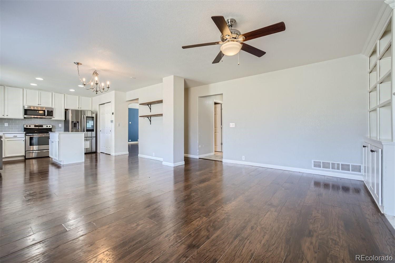 6632 Balance Circle Colorado Springs, CO 80923 - Photo 7 of 28 a view of a livingroom with wooden floor a ceiling fan and kitchen space