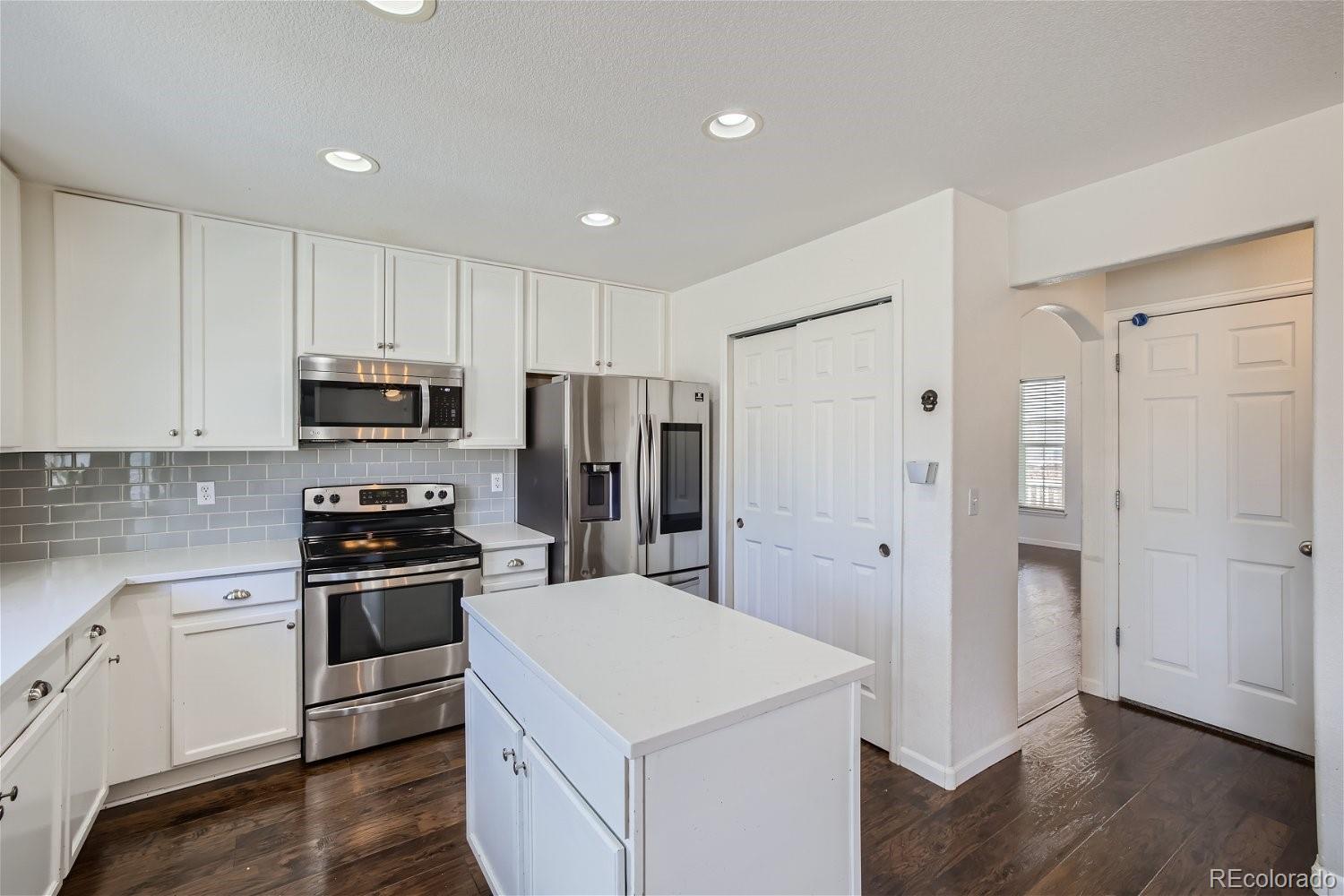 6632 Balance Circle Colorado Springs, CO 80923 - Photo 10 of 28 a kitchen with stainless steel appliances a refrigerator stove and white cabinets