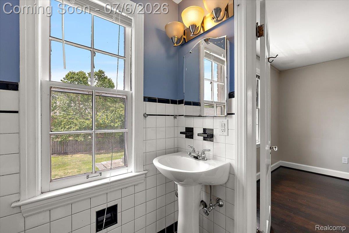 1051 Devonshire Road Grosse Pointe, MI 48230 - Photo 49 of 98 Pedestal sink with chrome fixtures and a mirrored medicine cabinet