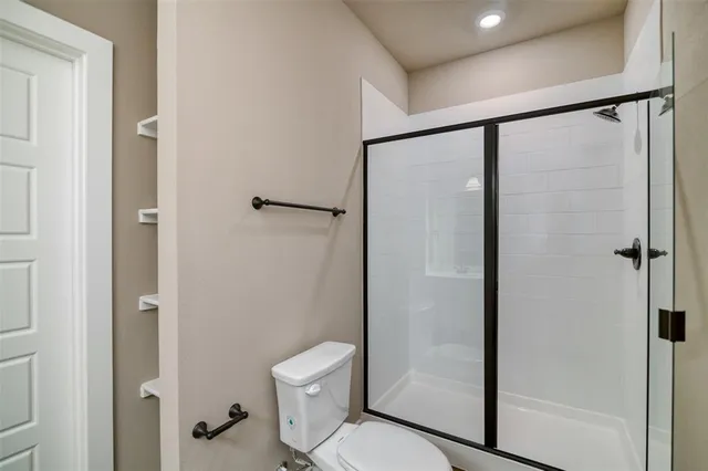 a bathroom with a shower a toilet and a sink