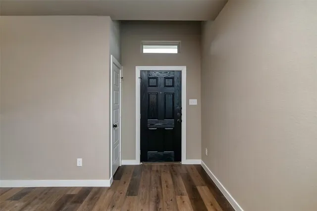 a view of a hallway with wooden floor and a window