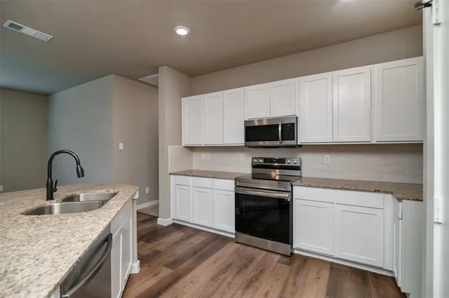 a kitchen with granite countertop stainless steel appliances and sink