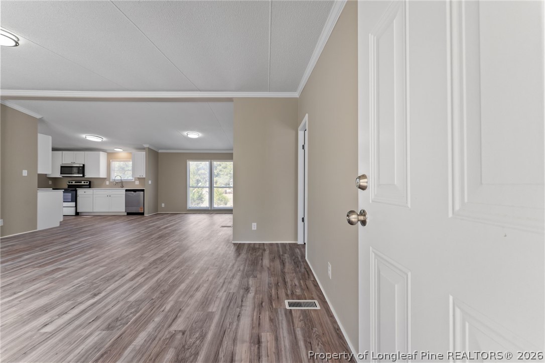 515 Mt Zion Road Red Springs, NC 28377 - Photo 12 of 50 a view of a hallway with wooden floor and a kitchen