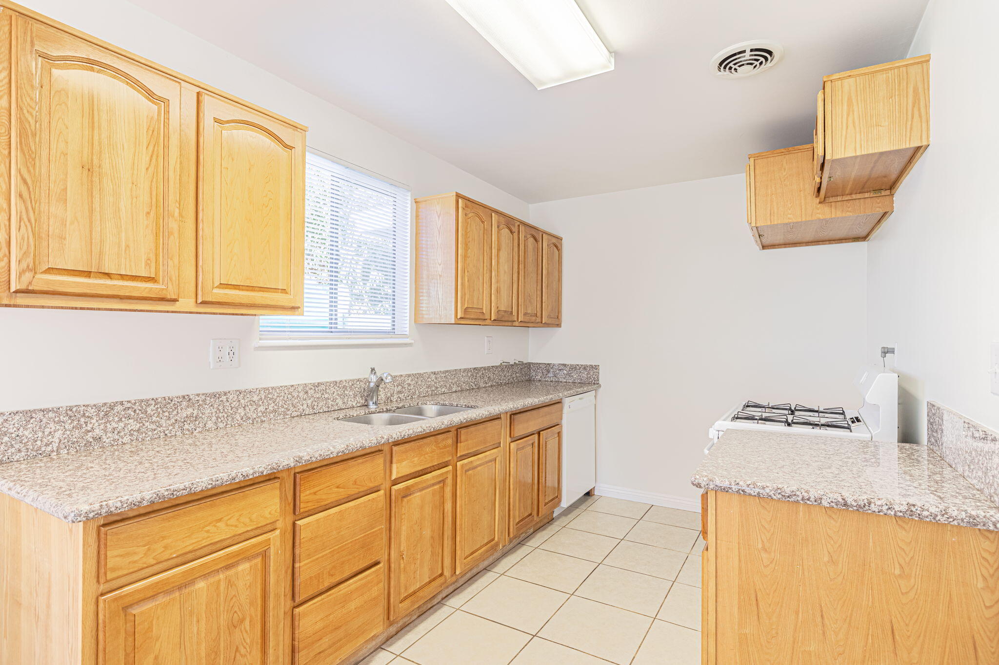 44015 Elm Avenue Lancaster, CA 93534 - Photo 14 of 22 a kitchen with granite countertop a sink and a stove