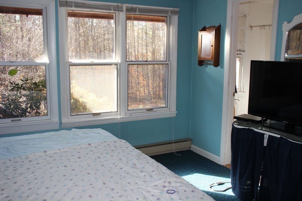 19 Ford Hill Road Rowe, MA 01367 - Photo 26 of 41 a bedroom with a bed and a flat tv screen next to a window