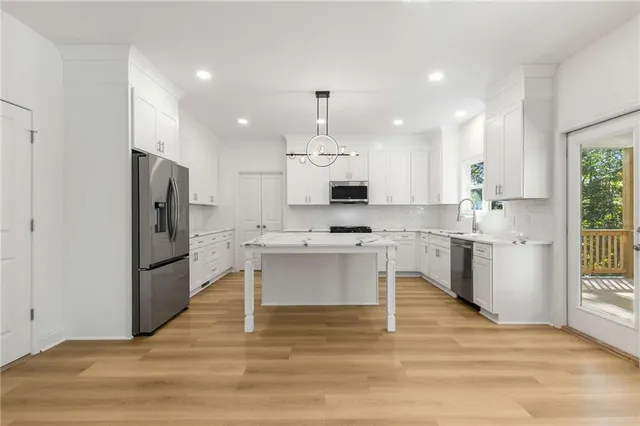 a kitchen with cabinets stainless steel appliances and a sink
