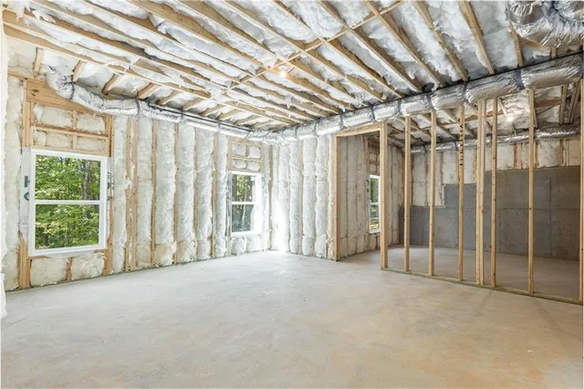 a spacious bedroom with a bed and wooden floor
