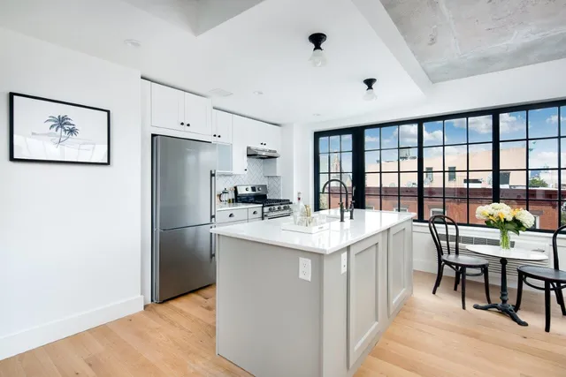 a large white kitchen with a large window