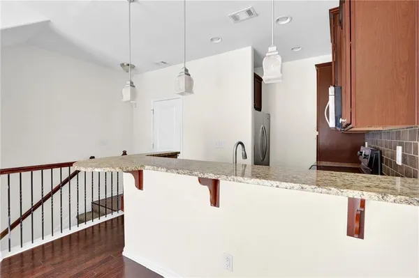 a kitchen with stainless steel appliances granite countertop a sink and a refrigerator