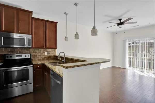 a kitchen with a sink a microwave and cabinets