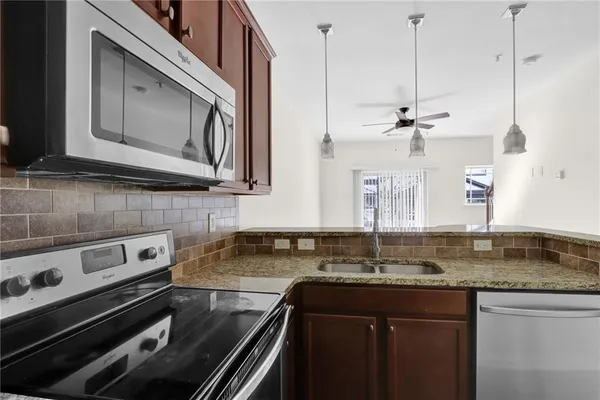 a kitchen that has a sink a stove and cabinets