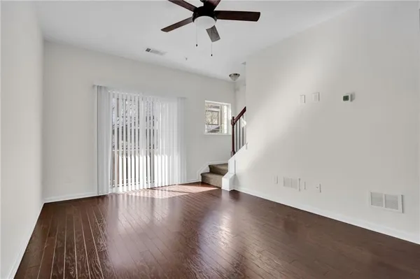 a view of a livingroom with wooden floor and a ceiling fan