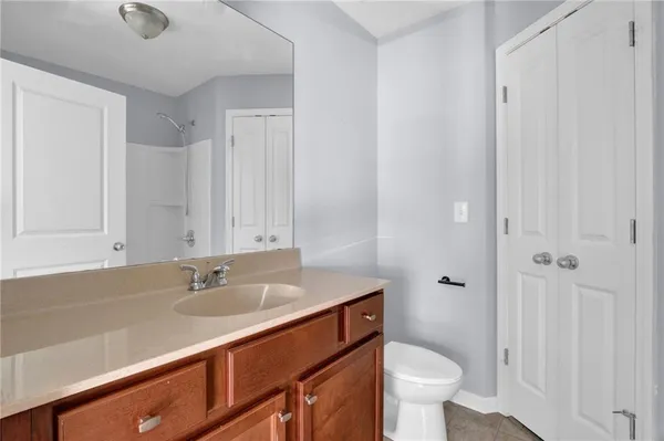a bathroom with a sink a toilet a shower and a mirror