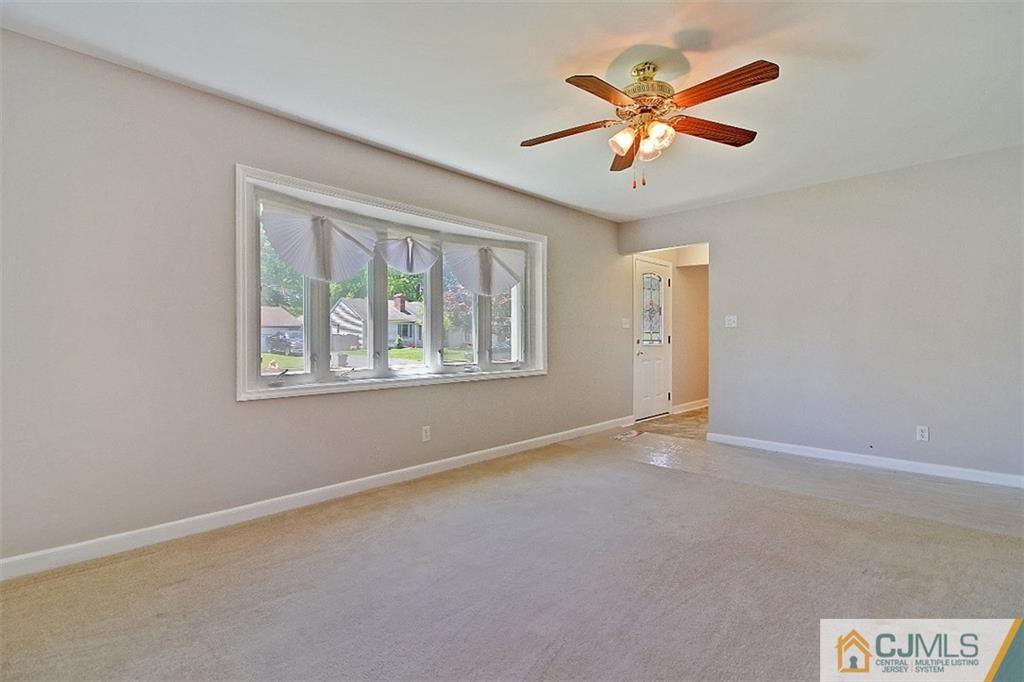 32 Ramsey Road Middlesex, NJ 08846 - Photo 2 of 25 an empty room with ceiling fan and windows