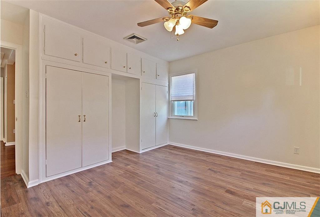 32 Ramsey Road Middlesex, NJ 08846 - Photo 18 of 25 an empty room with wooden floor cabinet and windows