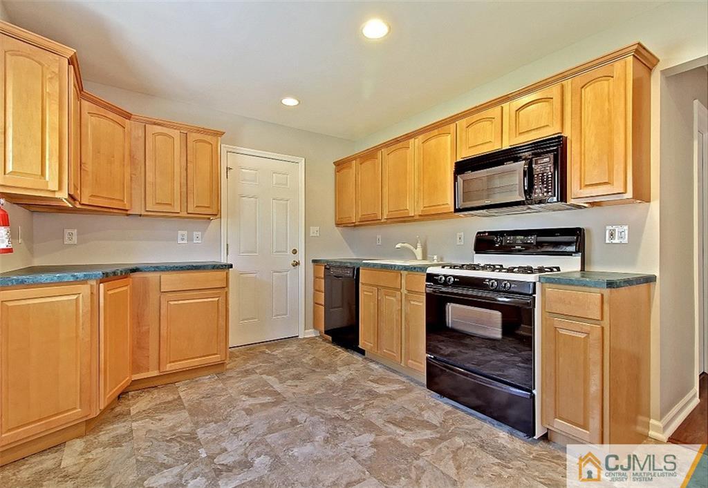 32 Ramsey Road Middlesex, NJ 08846 - Photo 4 of 25 a kitchen with stainless steel appliances granite countertop a stove a sink and a microwave