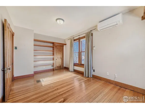 a view of empty room with wooden floor