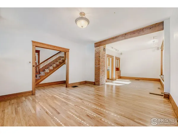 a view of an empty room with wooden floor