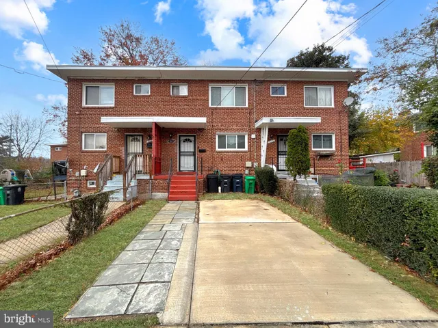 a front view of a house with a yard and potted plants