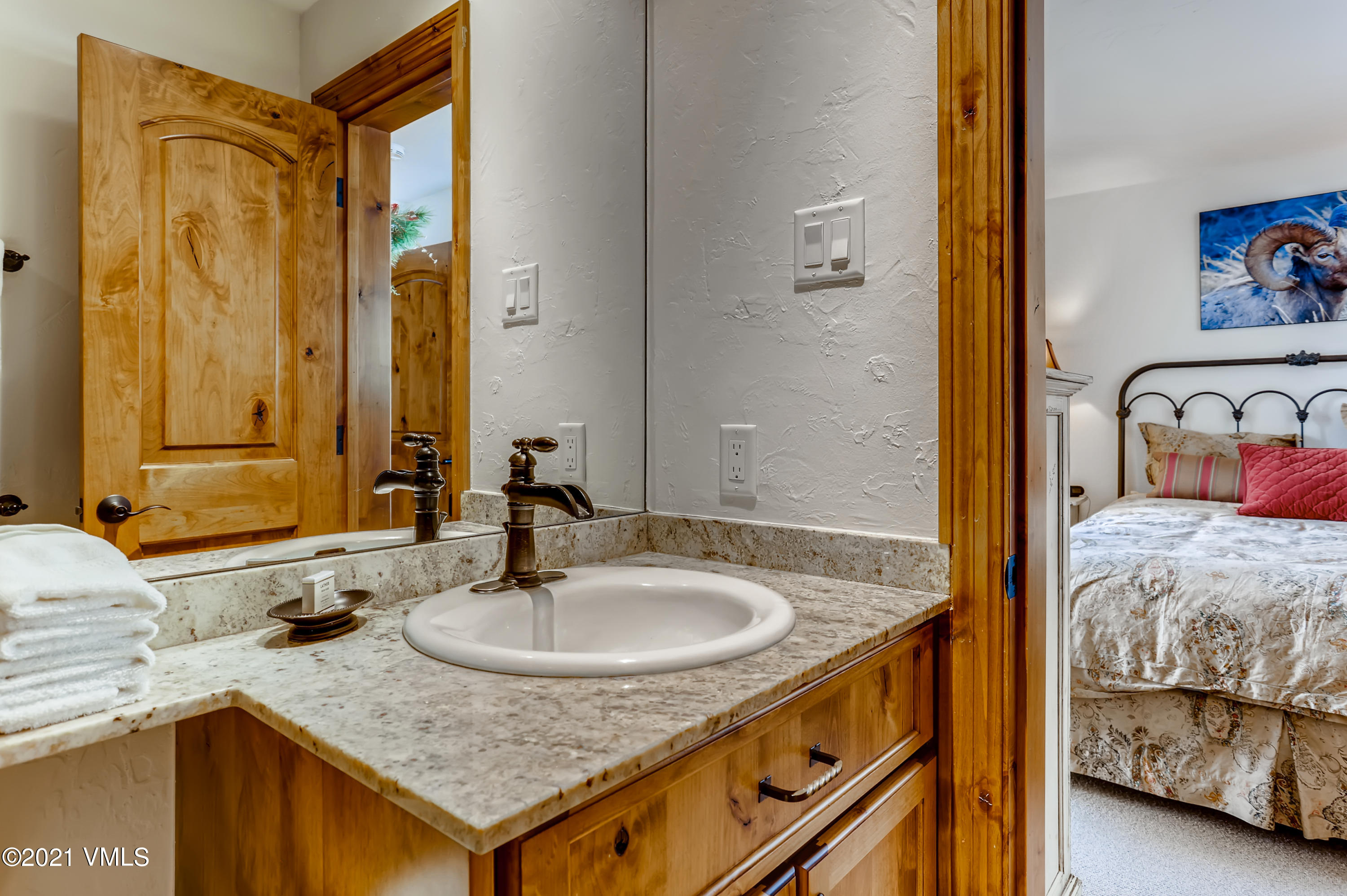 133 Willow Bridge Road, Unit 625 Vail, CO 81657 - Photo 20 of 26 a en suite bathroom with a granite countertop sink and a mirror