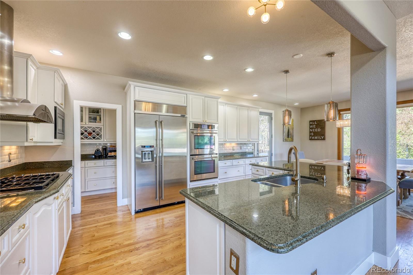 7963 Glen Ridge Drive Castle Pines, CO 80108 - Photo 11 of 48 a kitchen with stainless steel appliances granite countertop a sink a stove and a refrigerator