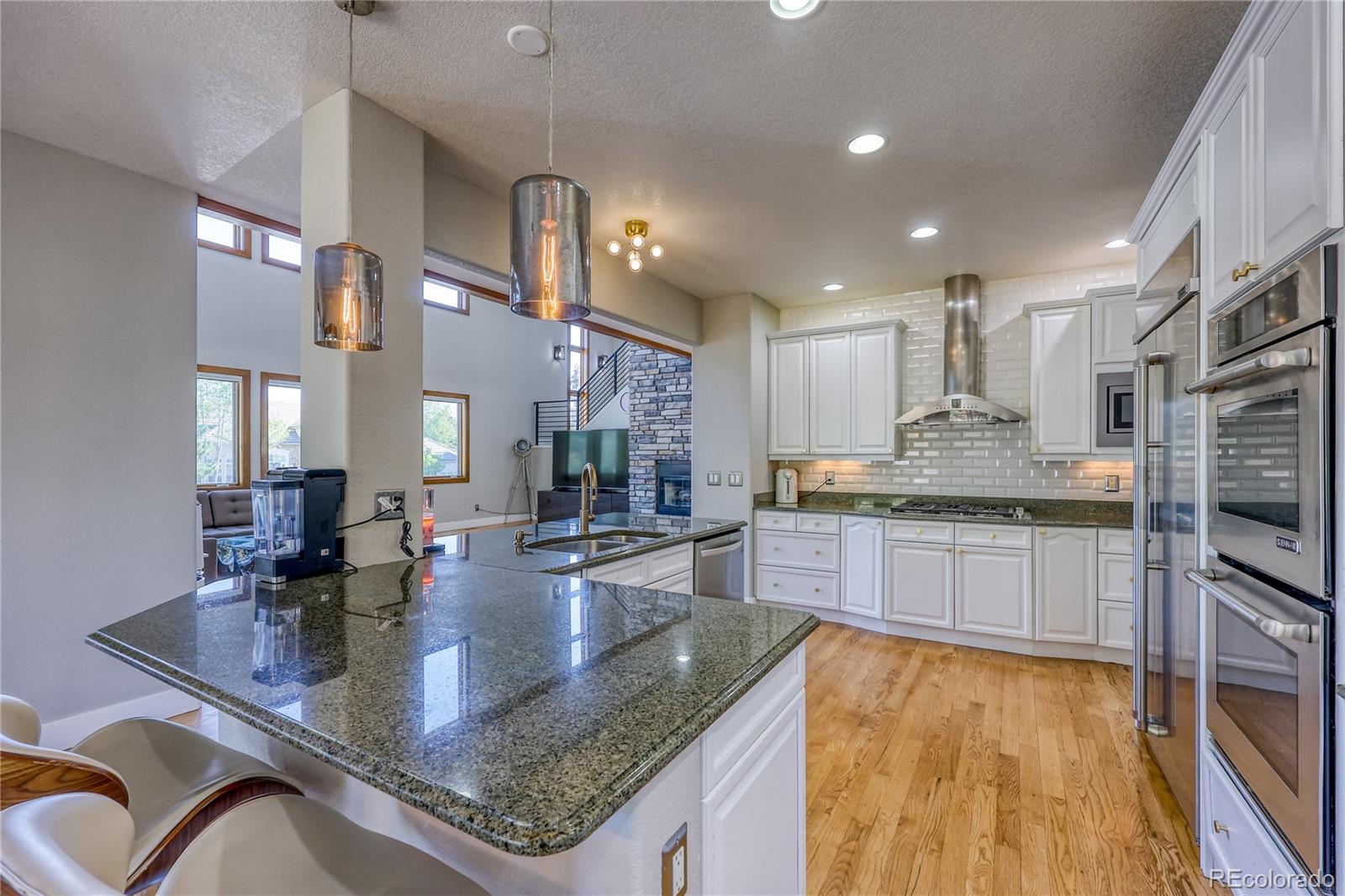 7963 Glen Ridge Drive Castle Pines, CO 80108 - Photo 12 of 48 a kitchen with stainless steel appliances granite countertop a sink a stove top oven a counter space and cabinets