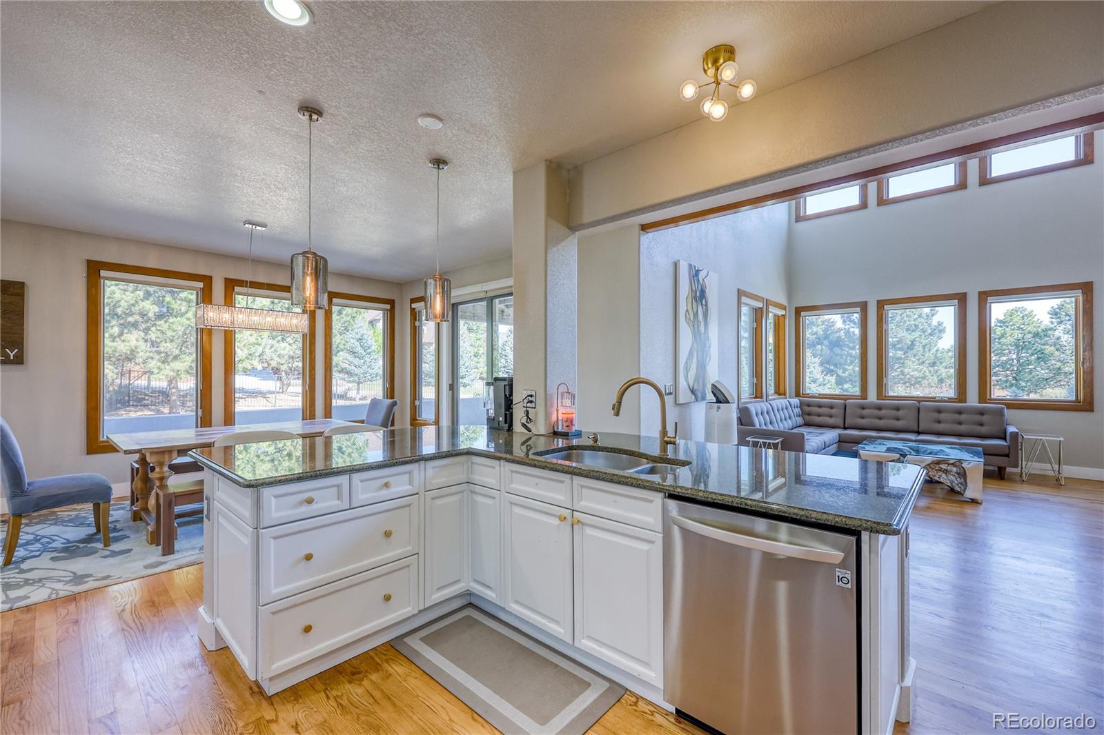 7963 Glen Ridge Drive Castle Pines, CO 80108 - Photo 14 of 48 a very nice looking kitchen with granite countertop a stove a sink a dining table and chairs with wooden floor