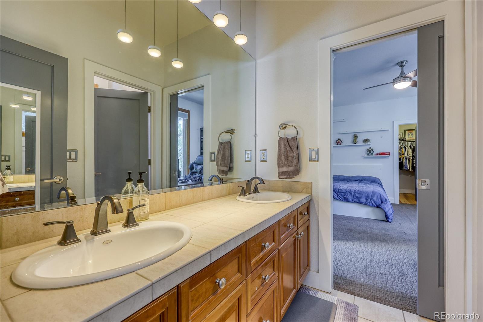 7963 Glen Ridge Drive Castle Pines, CO 80108 - Photo 23 of 48 a en suite bathroom with a sink and a mirror