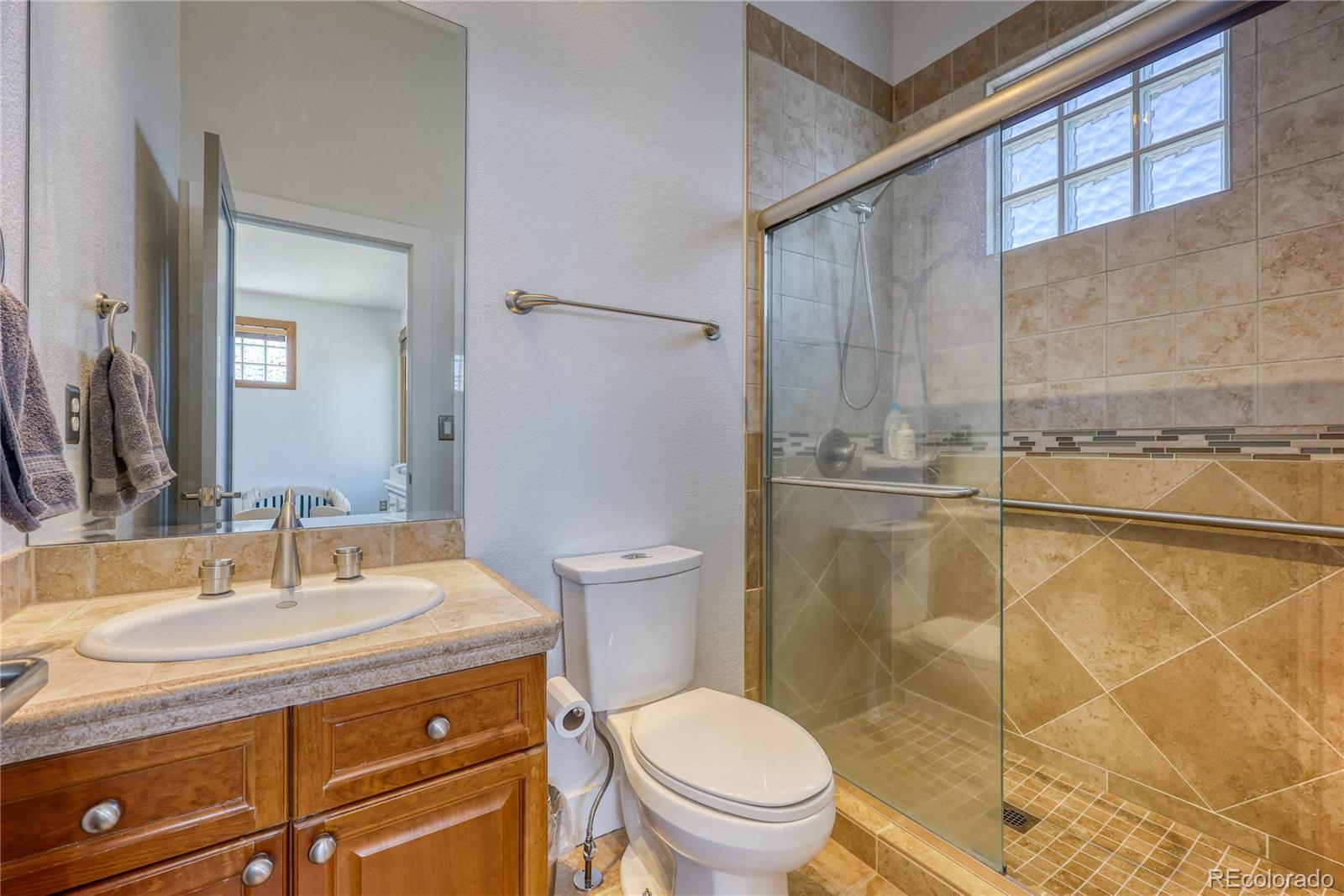 7963 Glen Ridge Drive Castle Pines, CO 80108 - Photo 25 of 48 a bathroom with a sink toilet and shower