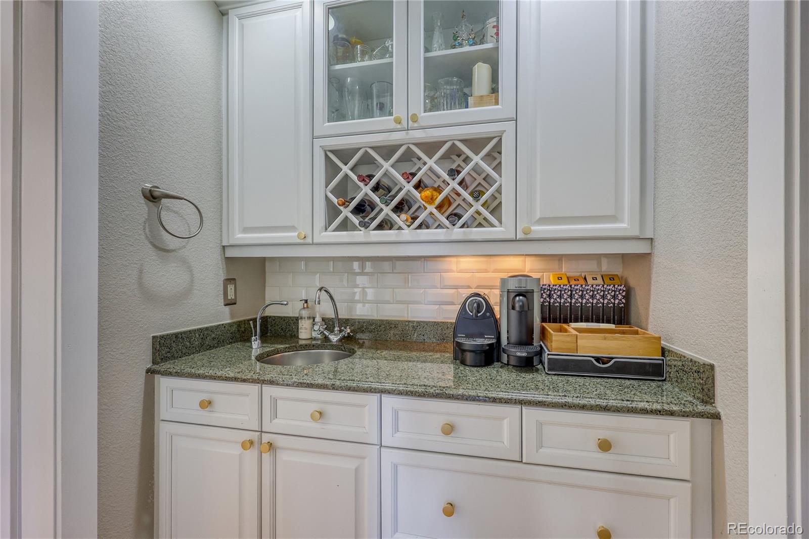 7963 Glen Ridge Drive Castle Pines, CO 80108 - Photo 28 of 48 a kitchen with granite countertop white cabinets and granite counter tops