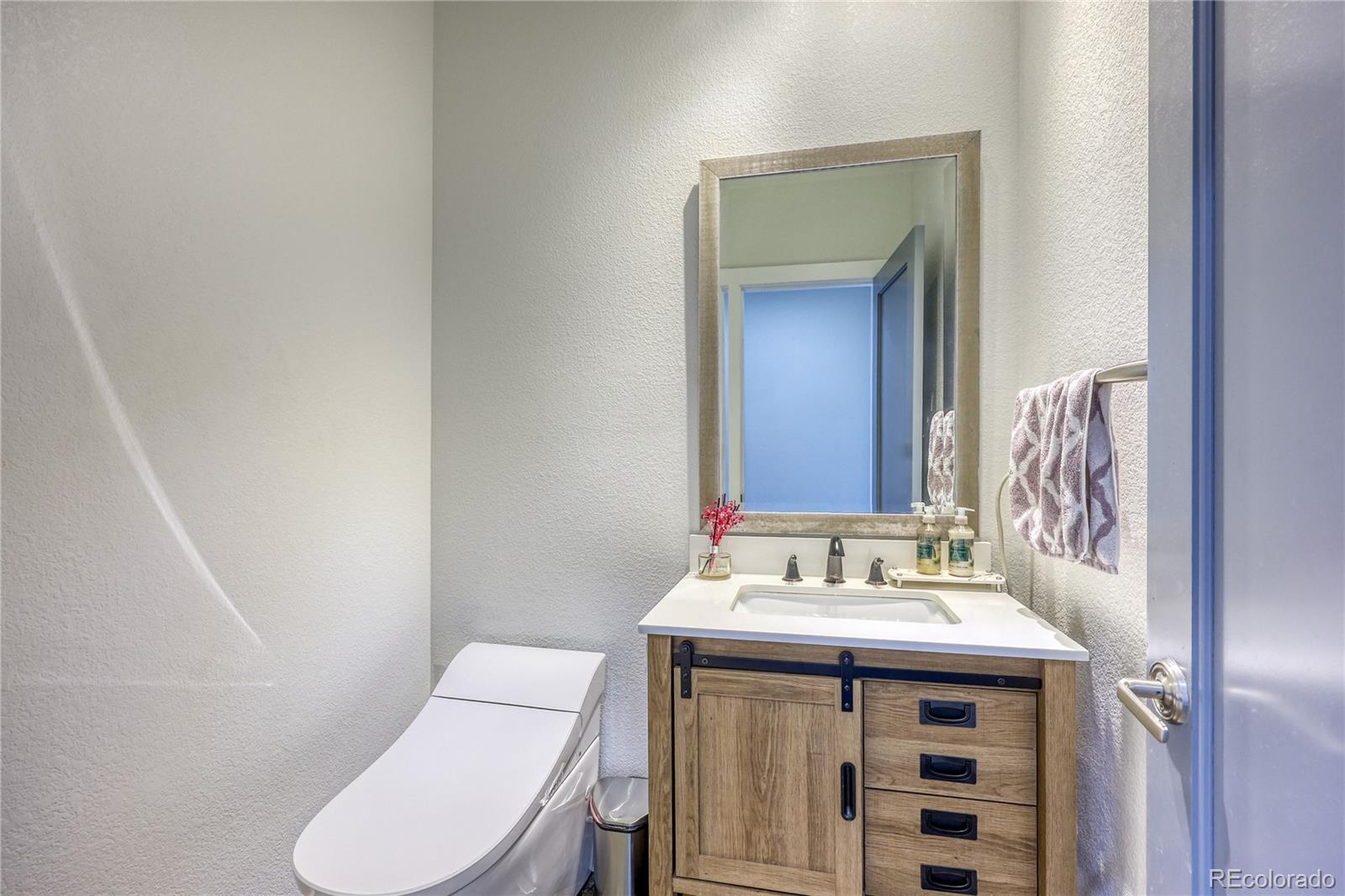 7963 Glen Ridge Drive Castle Pines, CO 80108 - Photo 31 of 48 a bathroom with a sink toilet and mirror